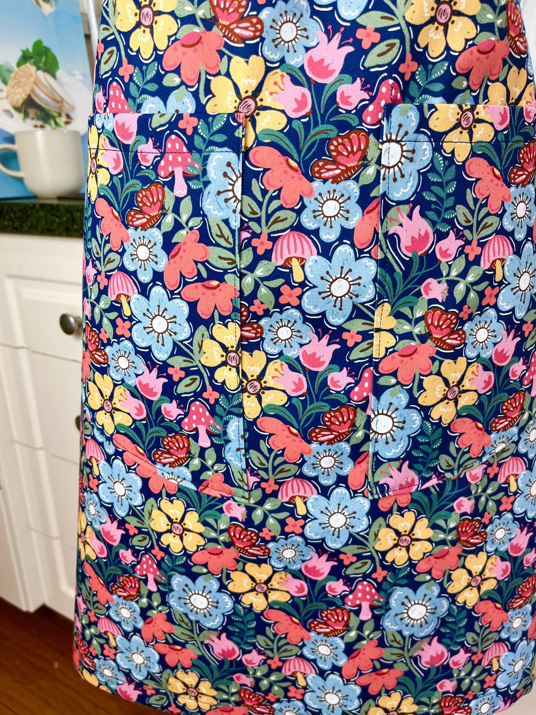 Hunt for the Adorable Butterflies and Mushrooms Within this Lovely Floral Apron